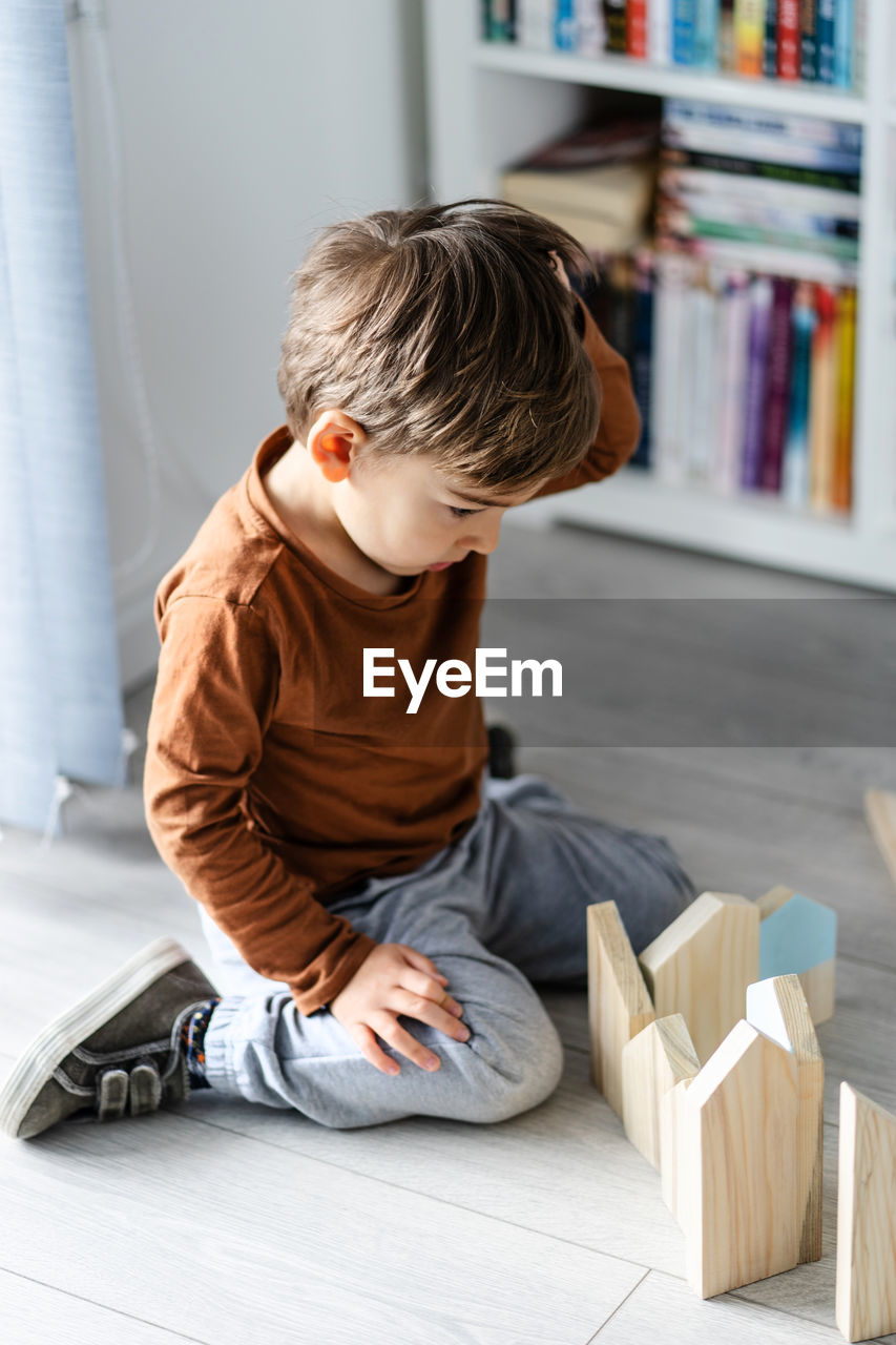 High angle view of boy sitting on floor at home