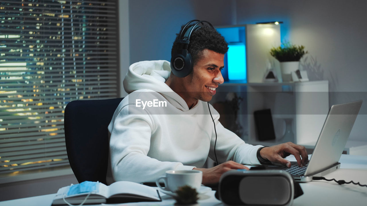 Smiling young man playing game at home