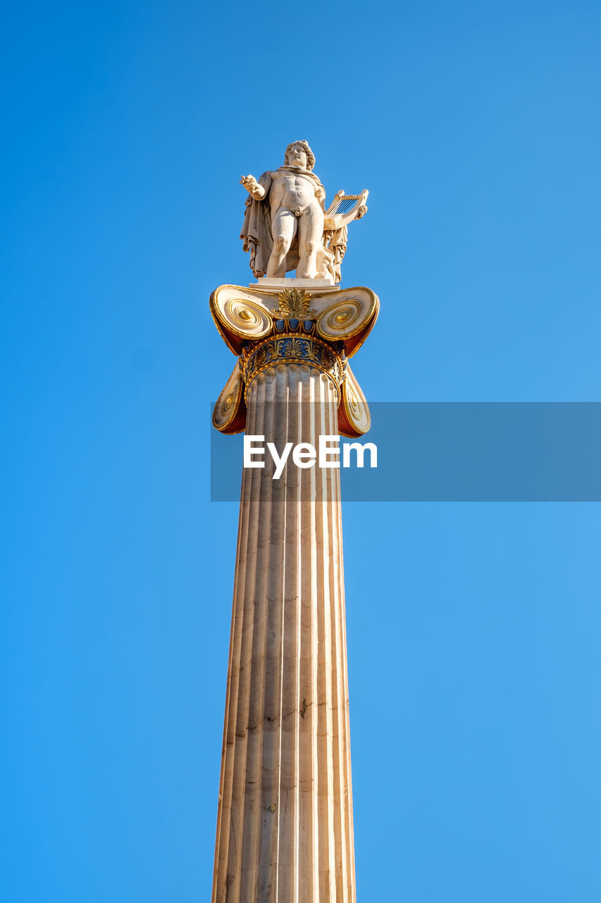 Low angle view of statue against blue sky