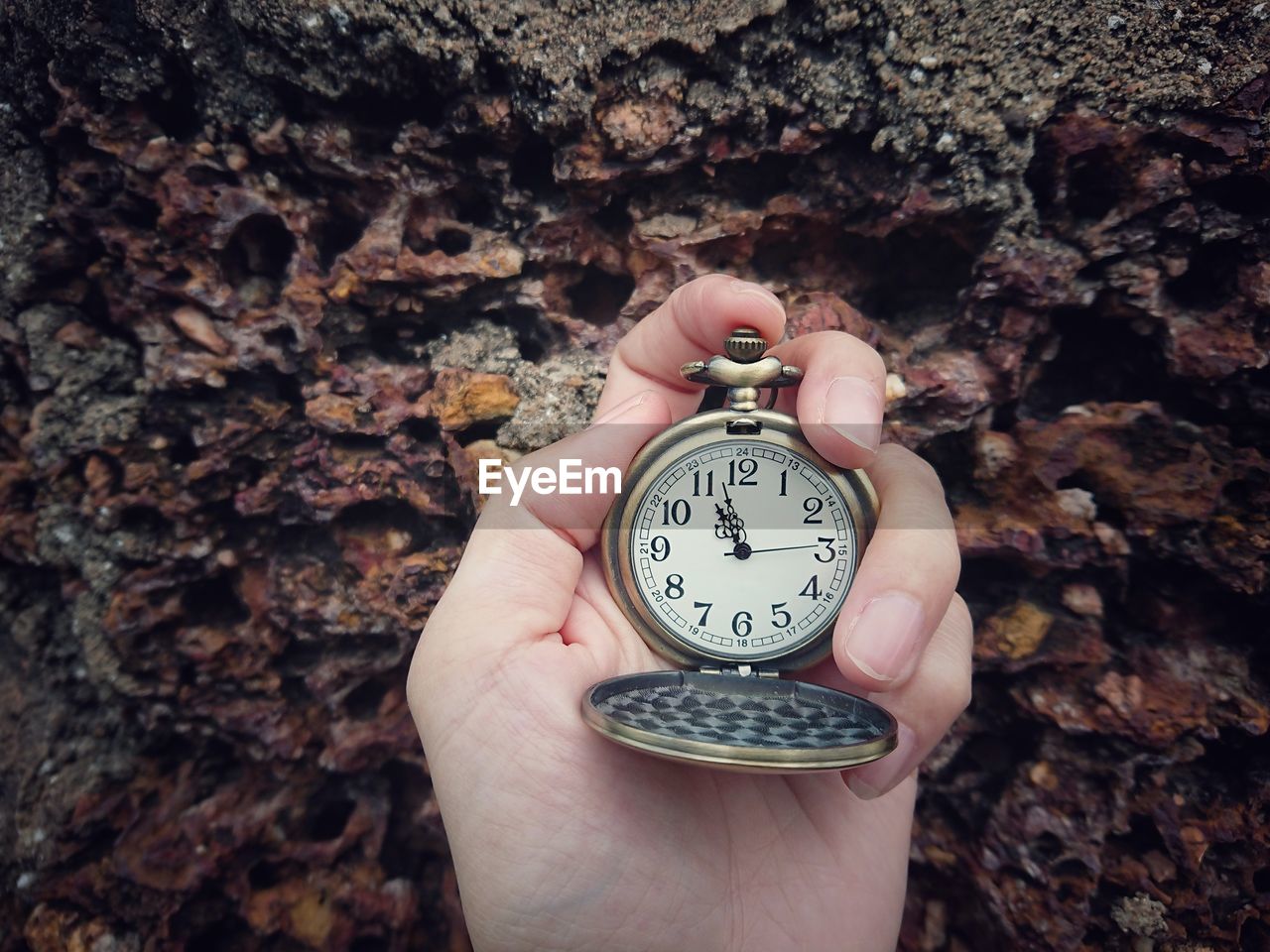 Cropped hand holding pocket watch