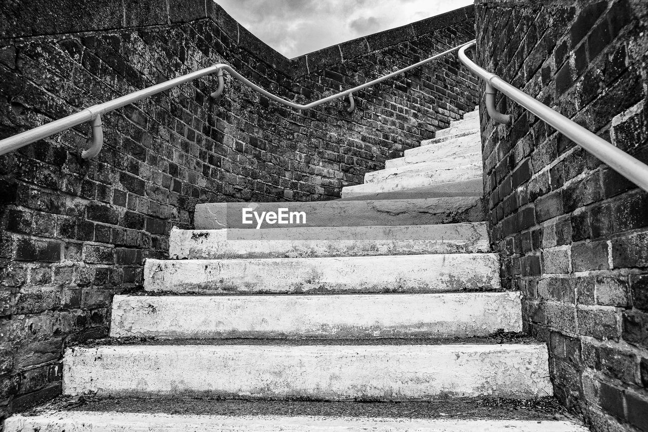 staircase, steps and staircases, architecture, stairs, built structure, black and white, railing, monochrome, low angle view, monochrome photography, wall, no people, the way forward, day, black, building exterior, nature, wall - building feature, outdoors, building, sky