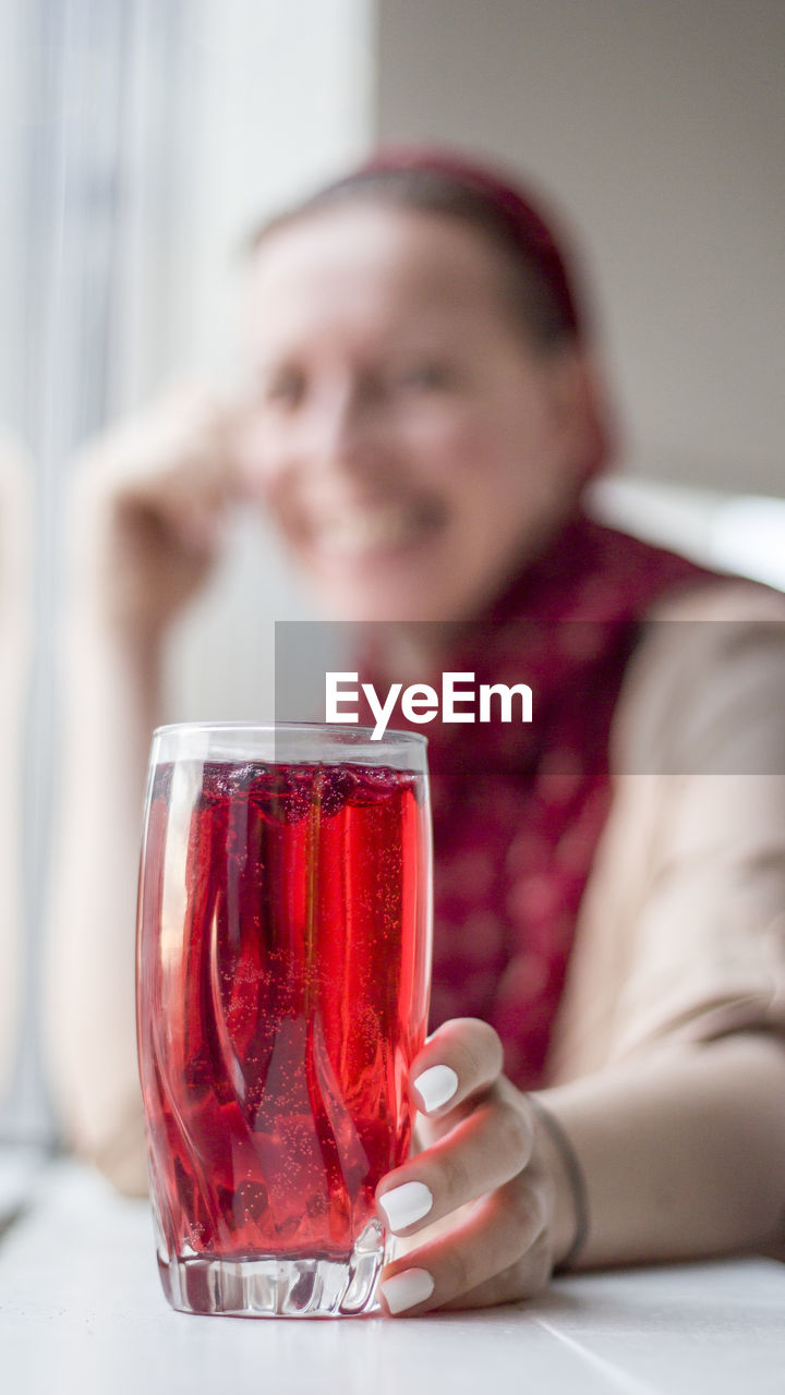 Woman having red juice at home