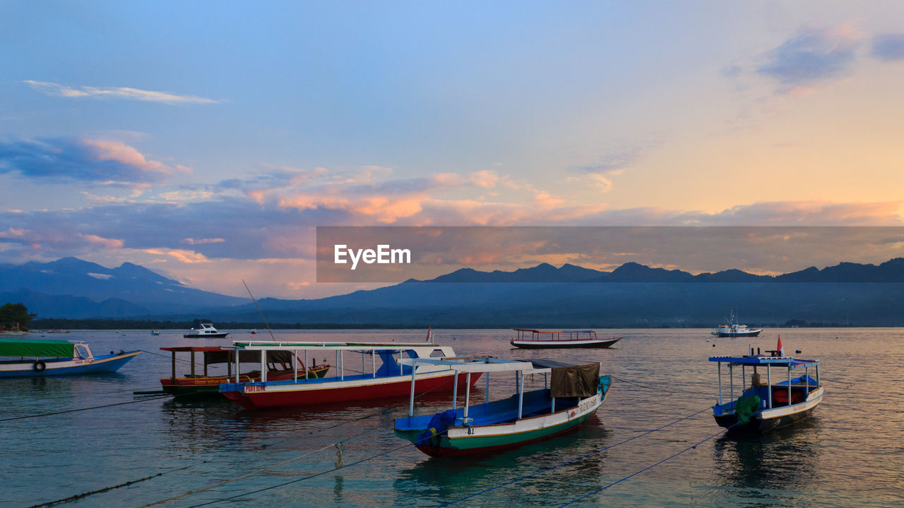 BOATS MOORED IN SEA AGAINST SKY