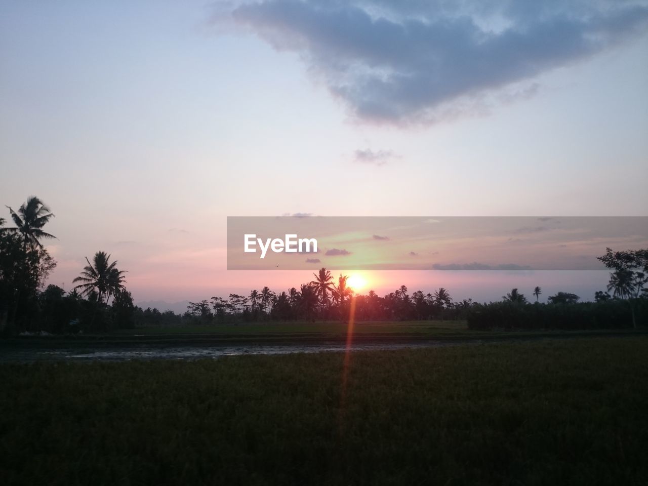 SCENIC VIEW OF SUNSET OVER FIELD