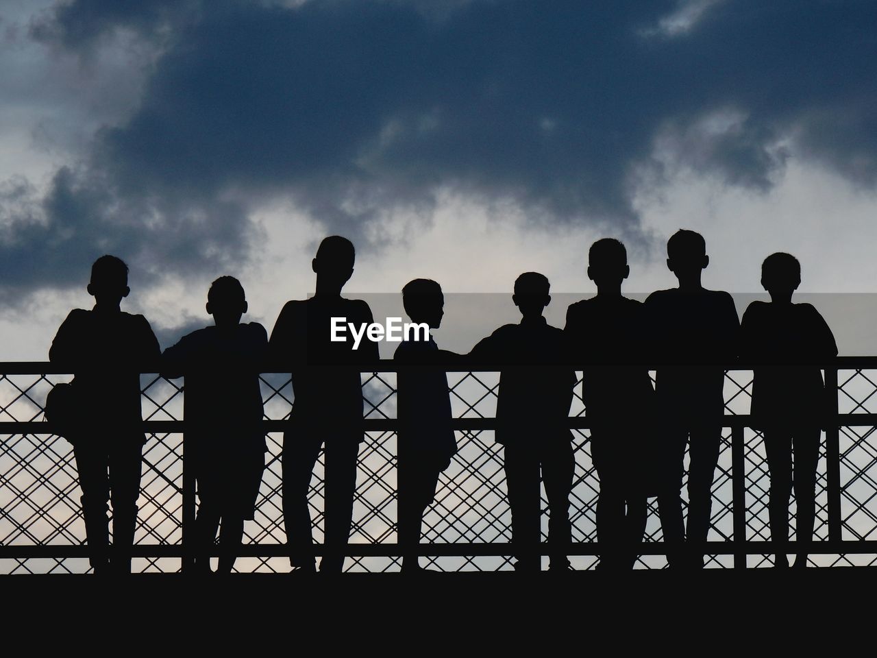 Group of children against cloudy sky