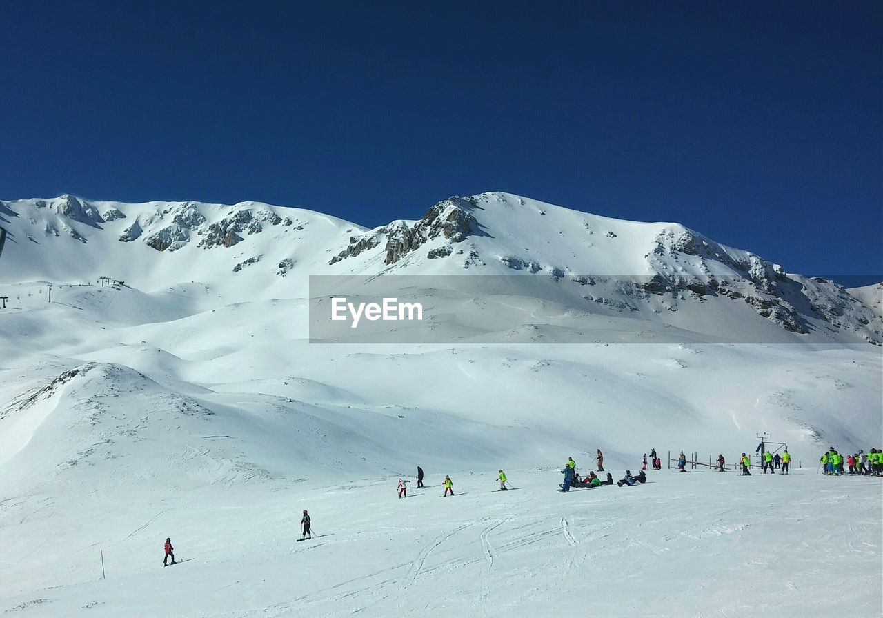 Tourists on snow covered mountain