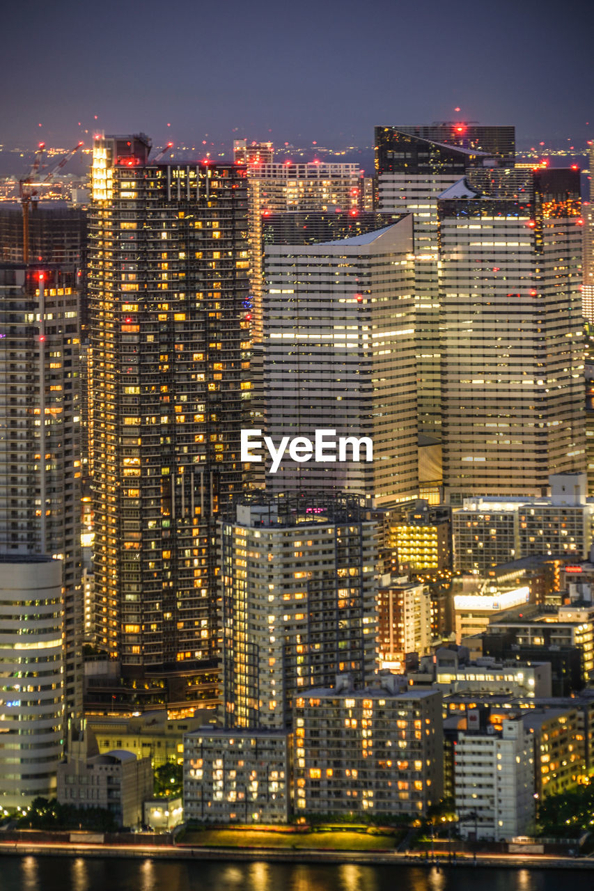 ILLUMINATED MODERN BUILDINGS IN CITY AT NIGHT