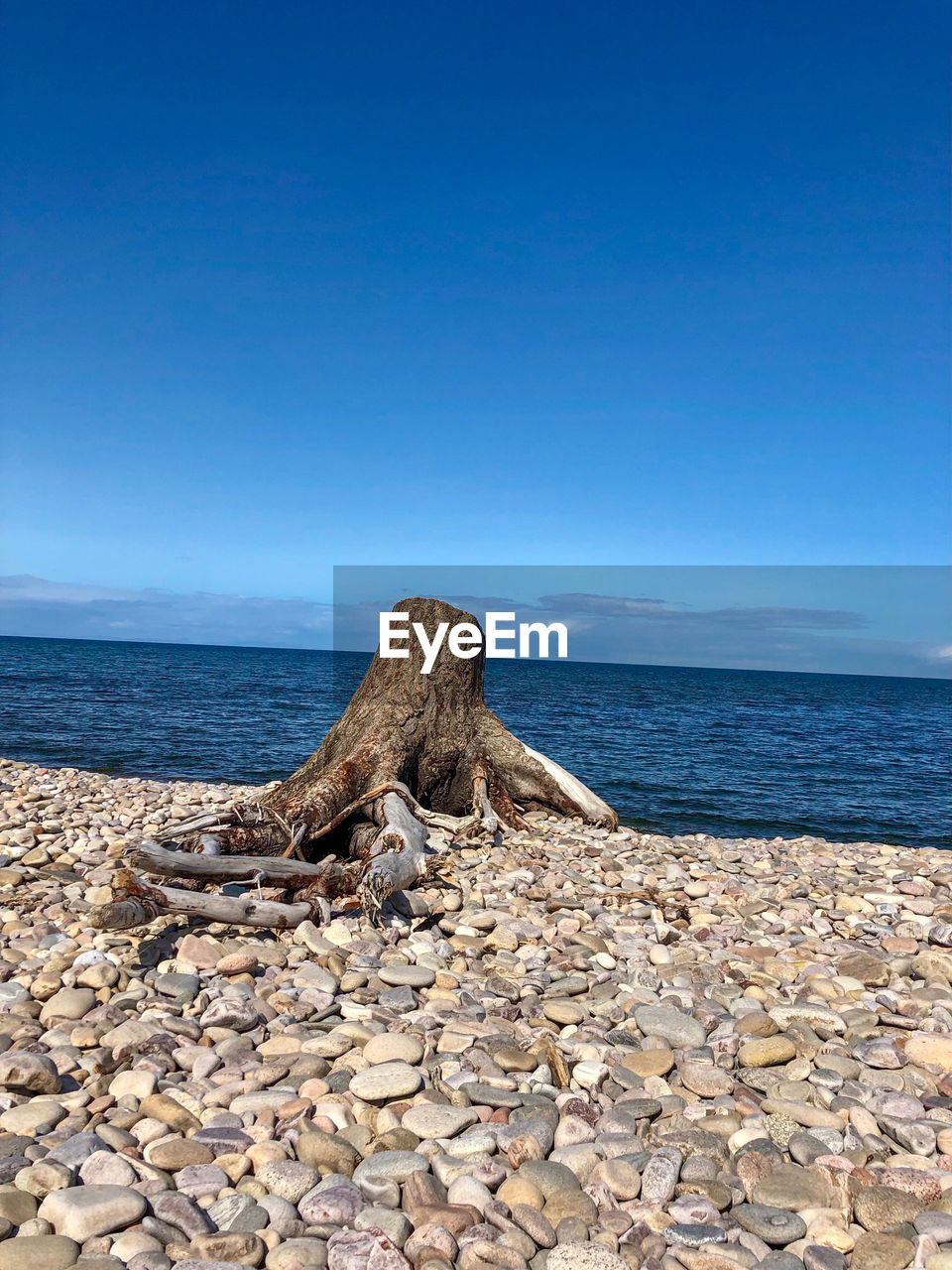 ROCKS ON BEACH AGAINST CLEAR SKY