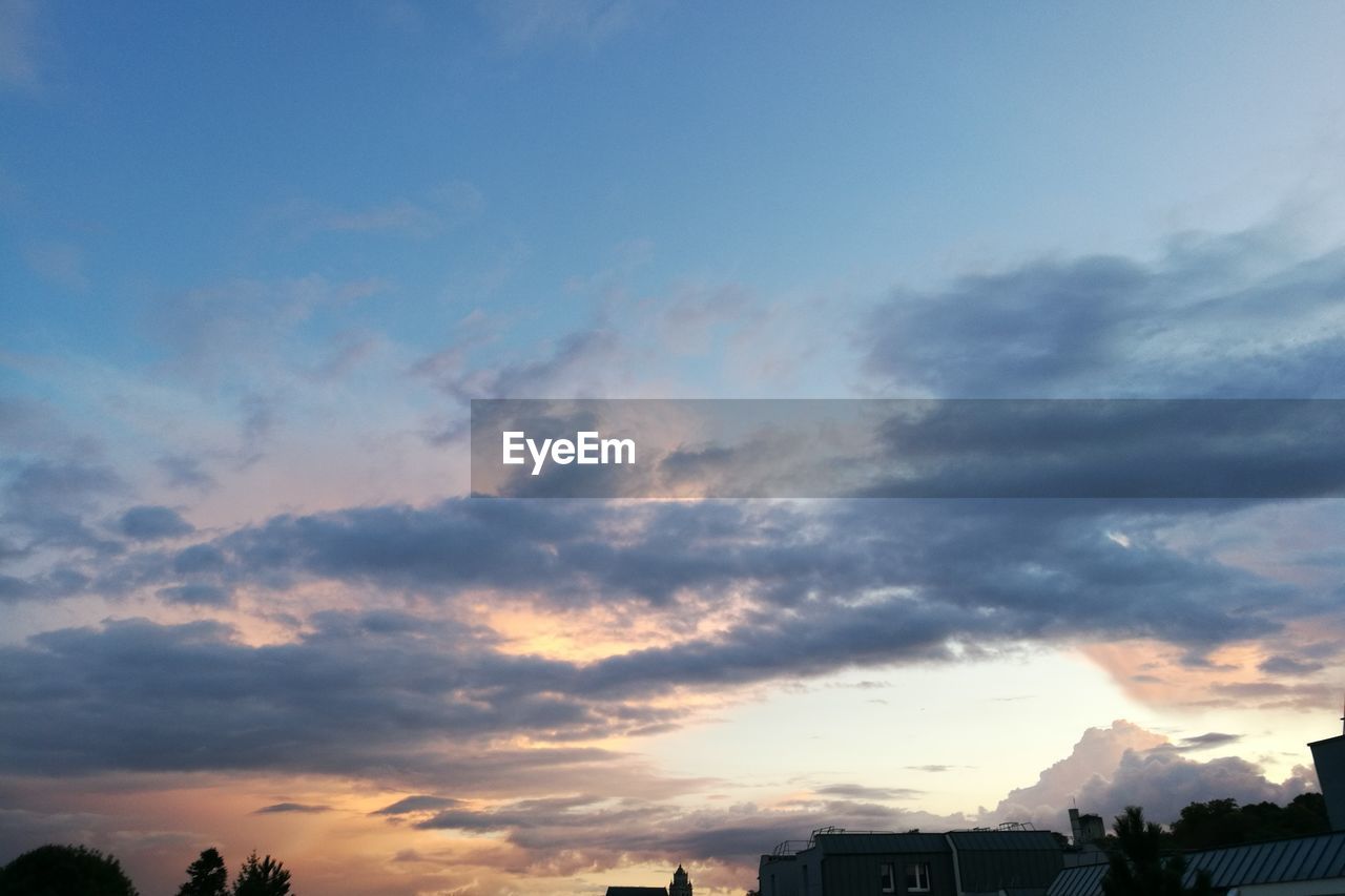 LOW ANGLE VIEW OF DRAMATIC SKY OVER SILHOUETTE BUILDINGS