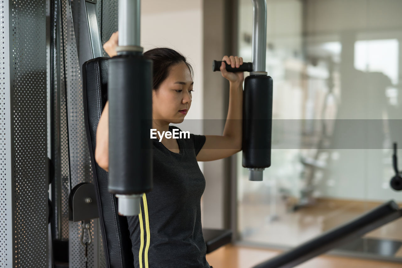 portrait of young woman exercising in gym