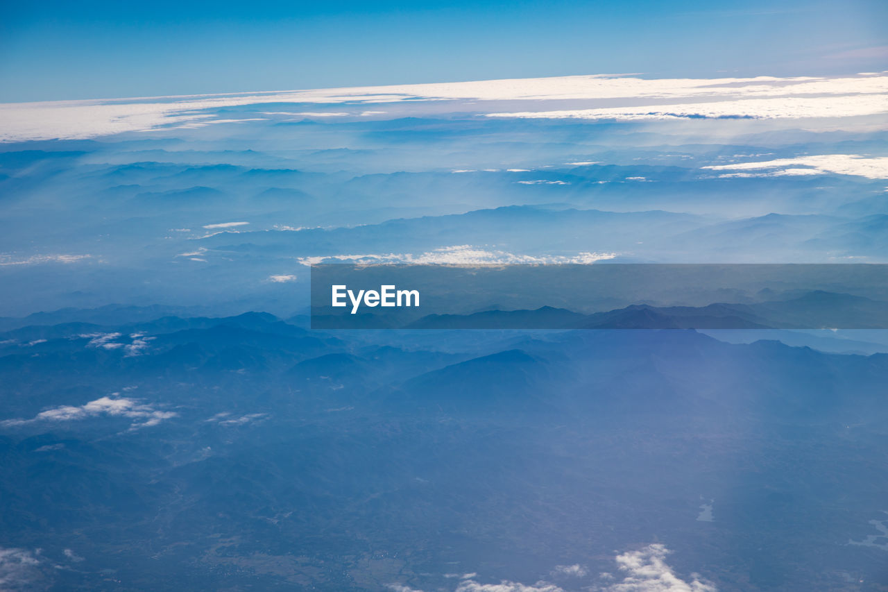 HIGH ANGLE VIEW OF CLOUDS OVER MOUNTAINS