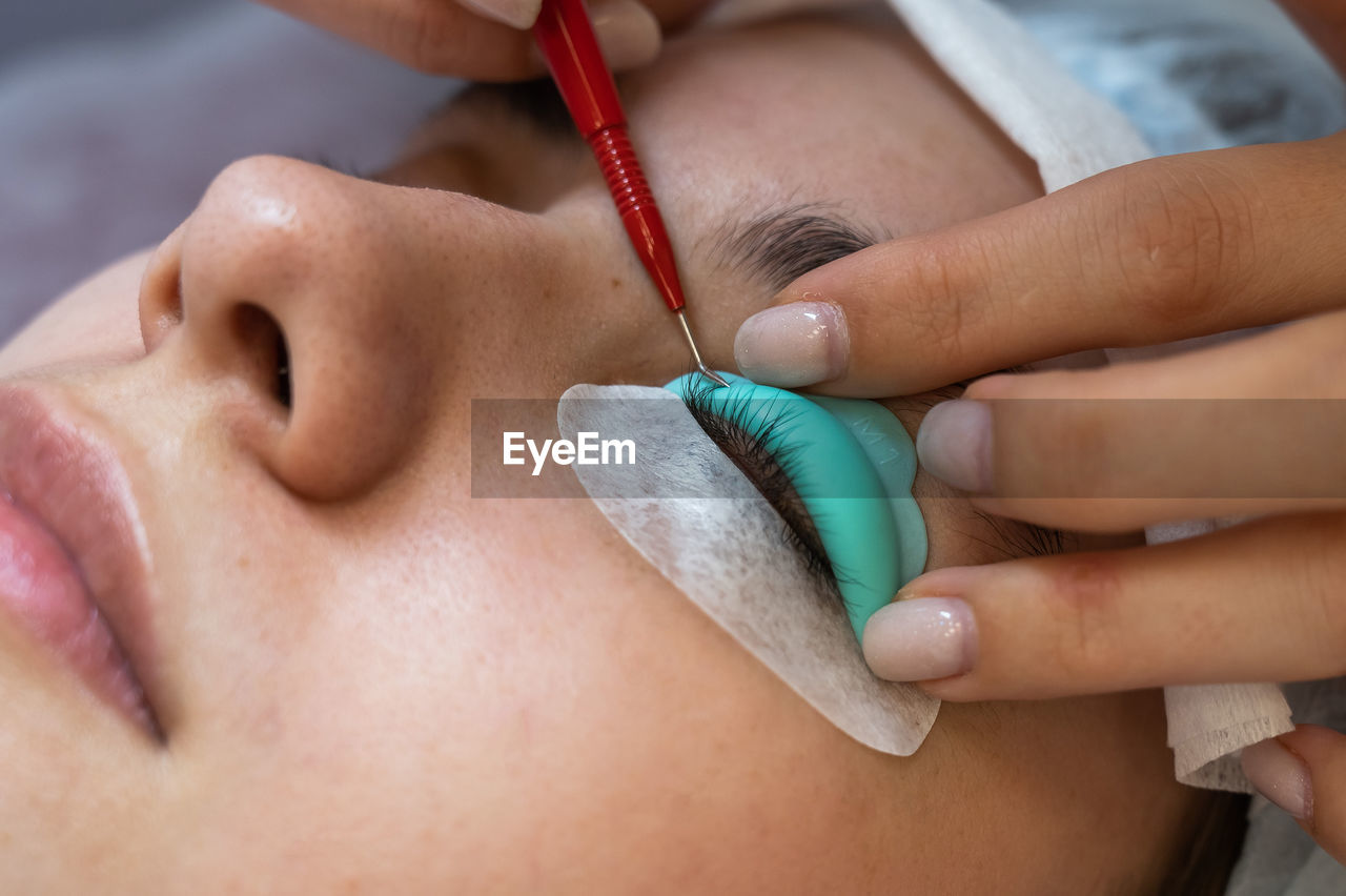 Cropped hand of beautician treating customer at spa