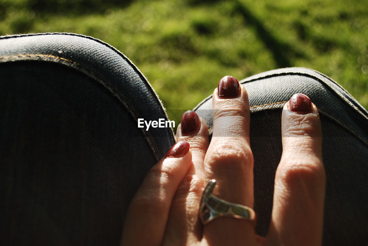 Cropped hand of woman touching seat outdoors