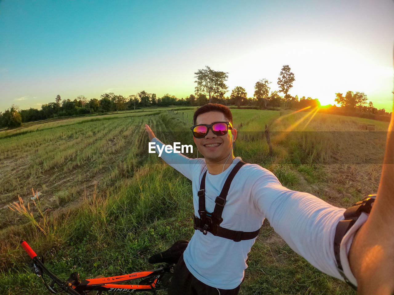 Portrait of young man wearing sunglasses on land against sky