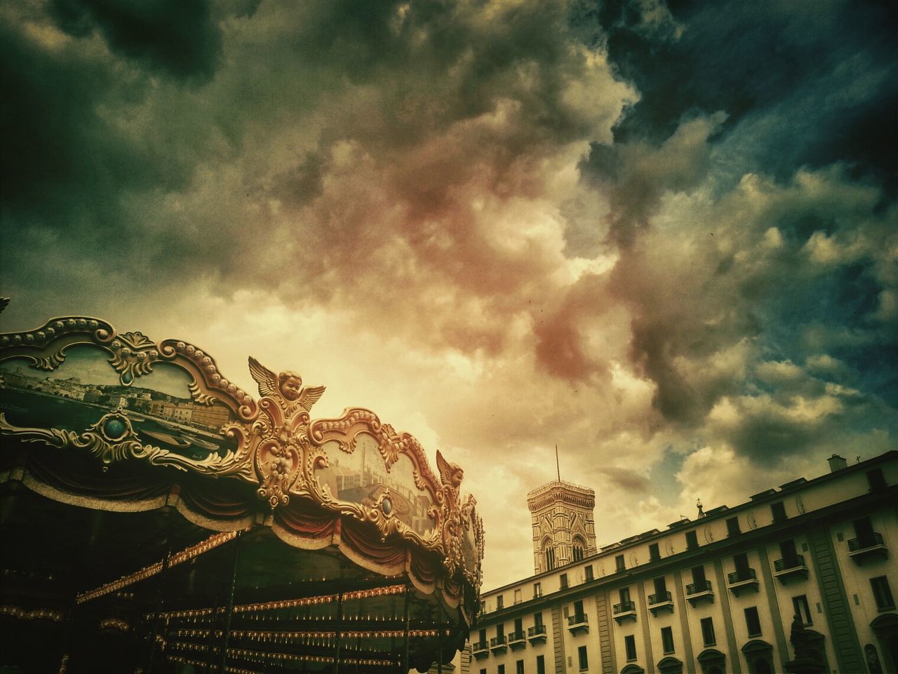 Swing carousel and building against dramatic sky