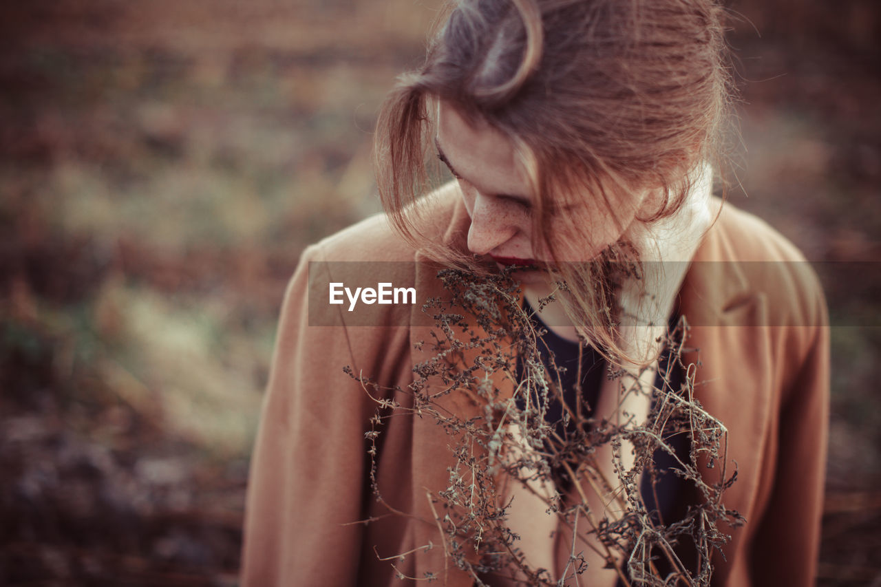 Portrait of young woman looking away outdoors