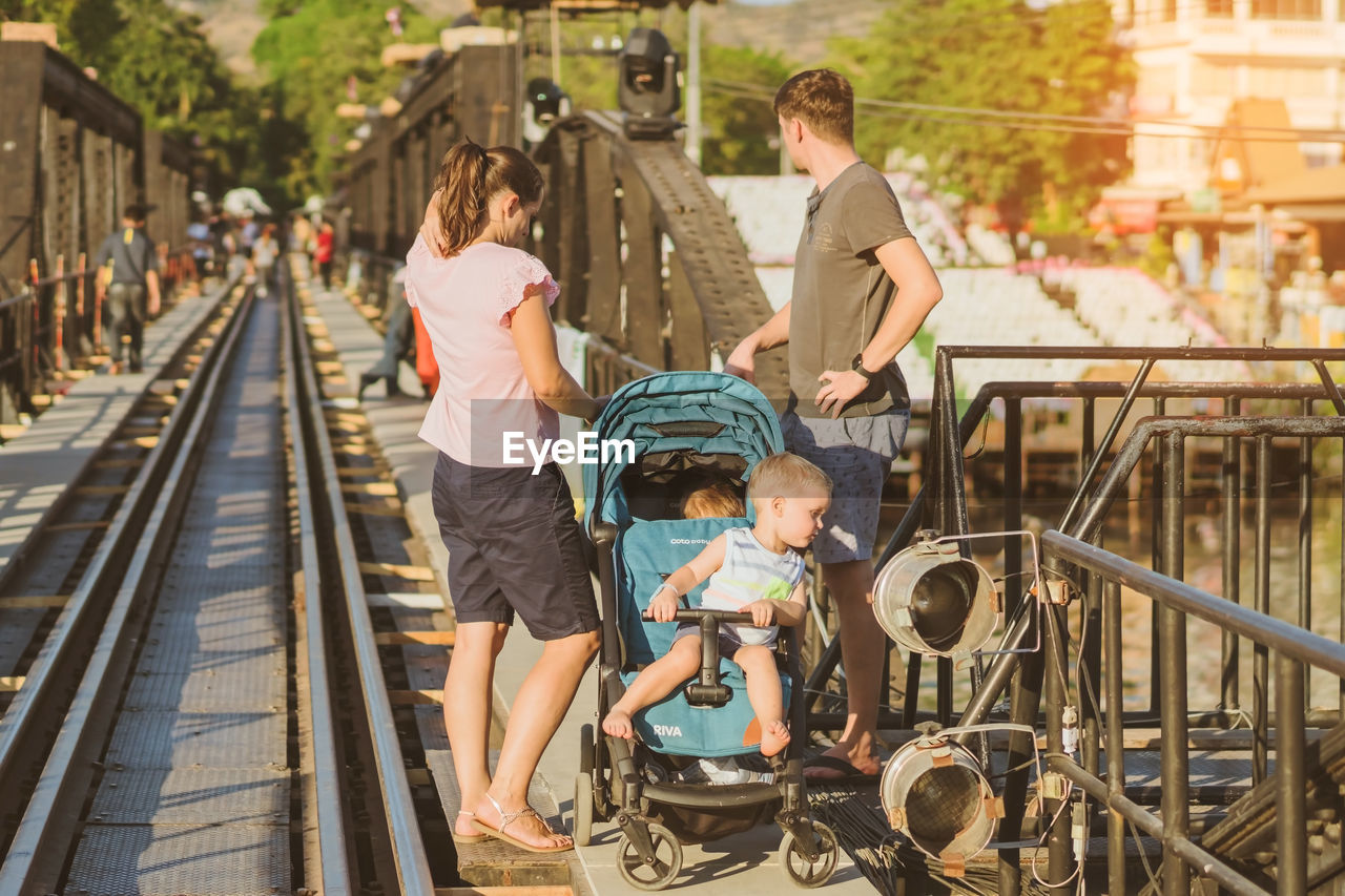 REAR VIEW OF PEOPLE ON RAILWAY TRACKS