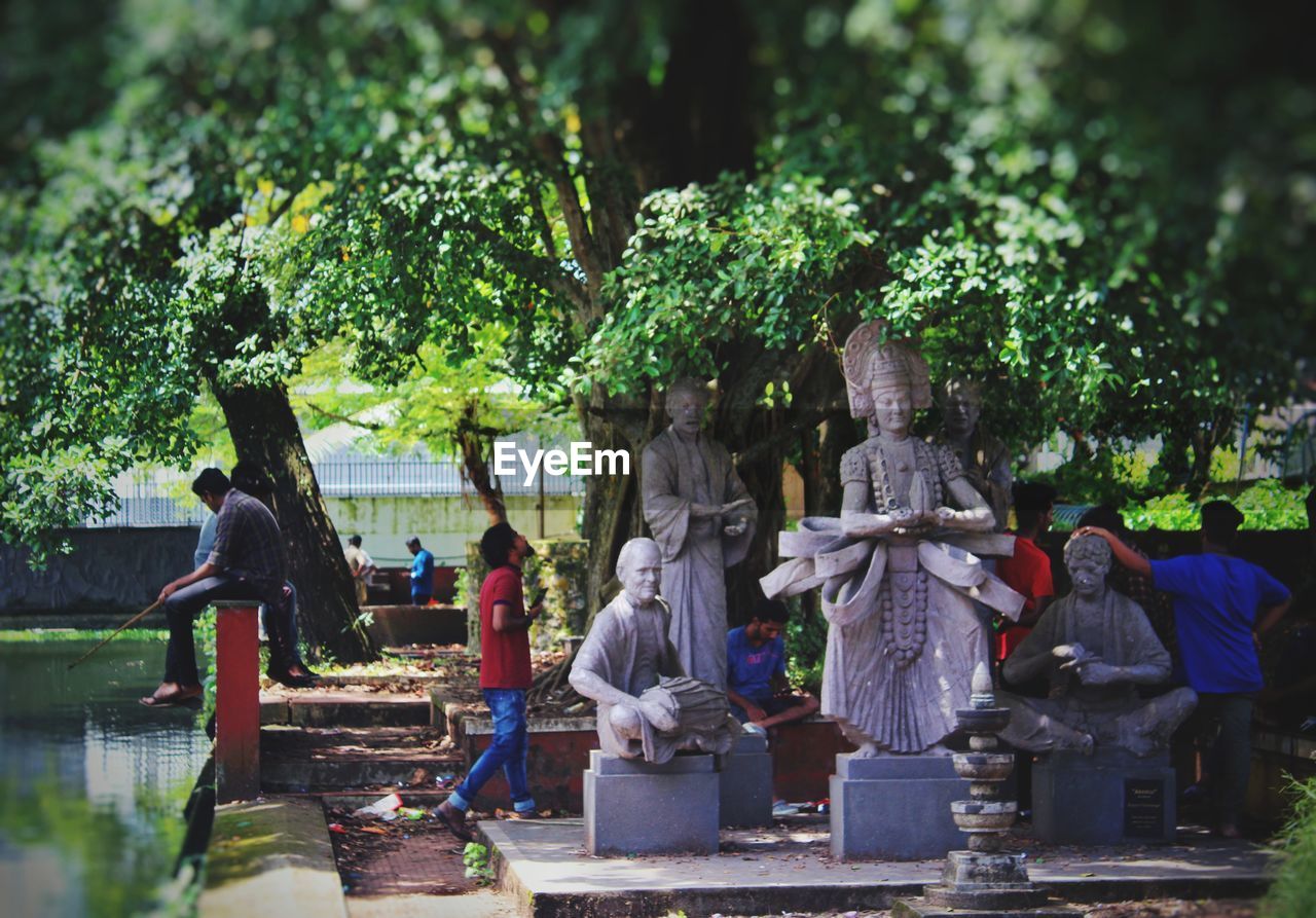 STATUE AGAINST TREES AND PLANTS