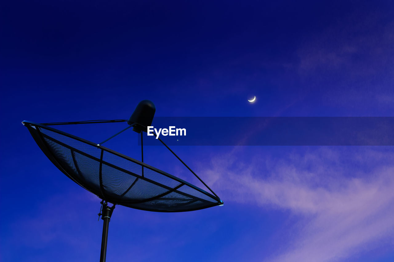 LOW ANGLE VIEW OF COMMUNICATIONS TOWER AGAINST SKY AT NIGHT