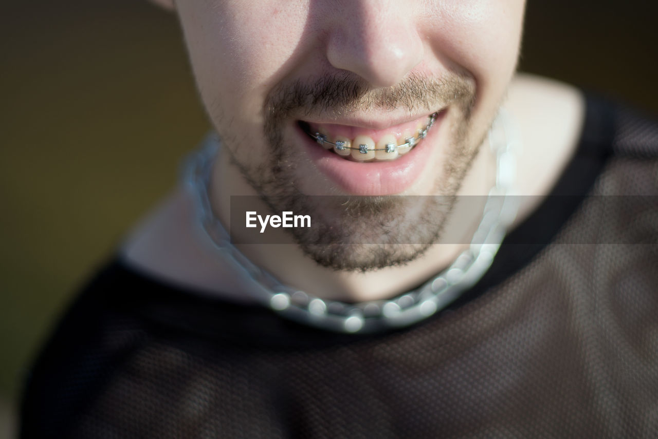 CLOSE-UP PORTRAIT OF A SMILING YOUNG MAN WEARING MASK