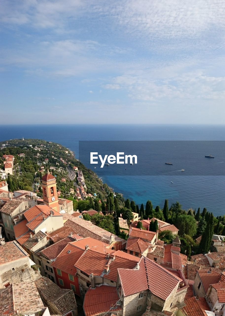 High angle view of houses by sea against sky