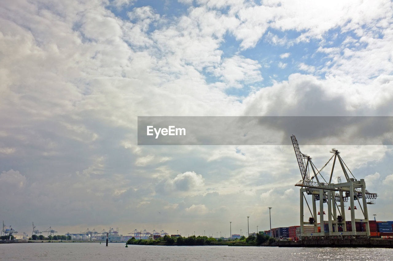Commercial dock against cloudy sky