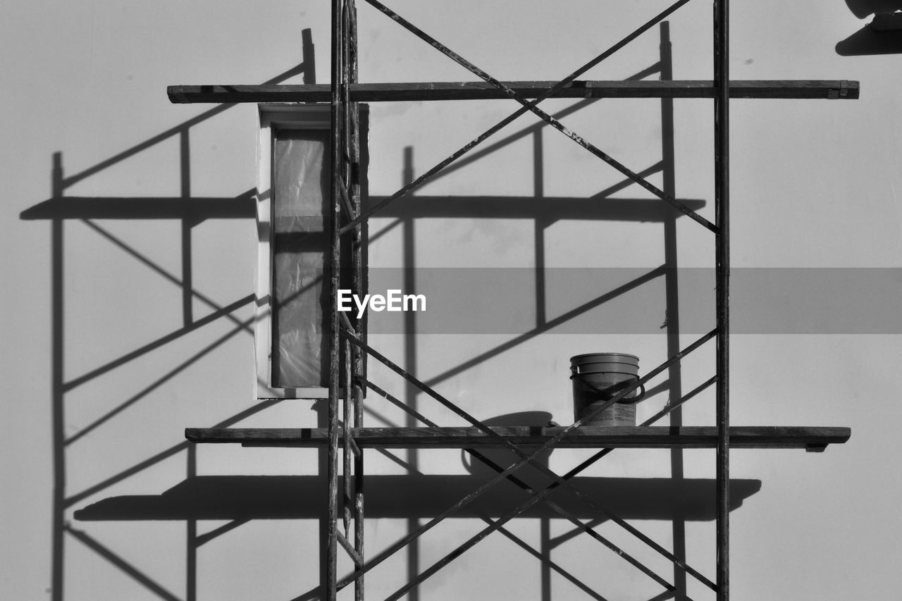 Paint can on scaffolding against wall