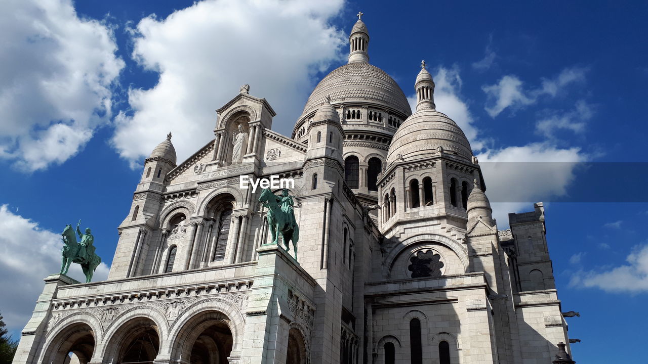 Low angle view of building against cloudy sky