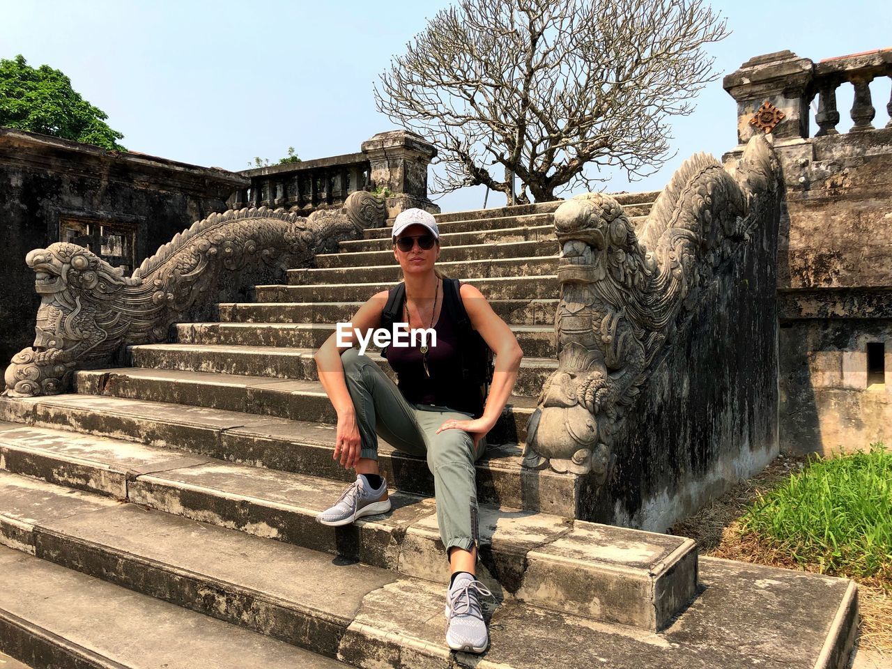 FULL LENGTH OF YOUNG MAN SITTING ON STAIRCASE