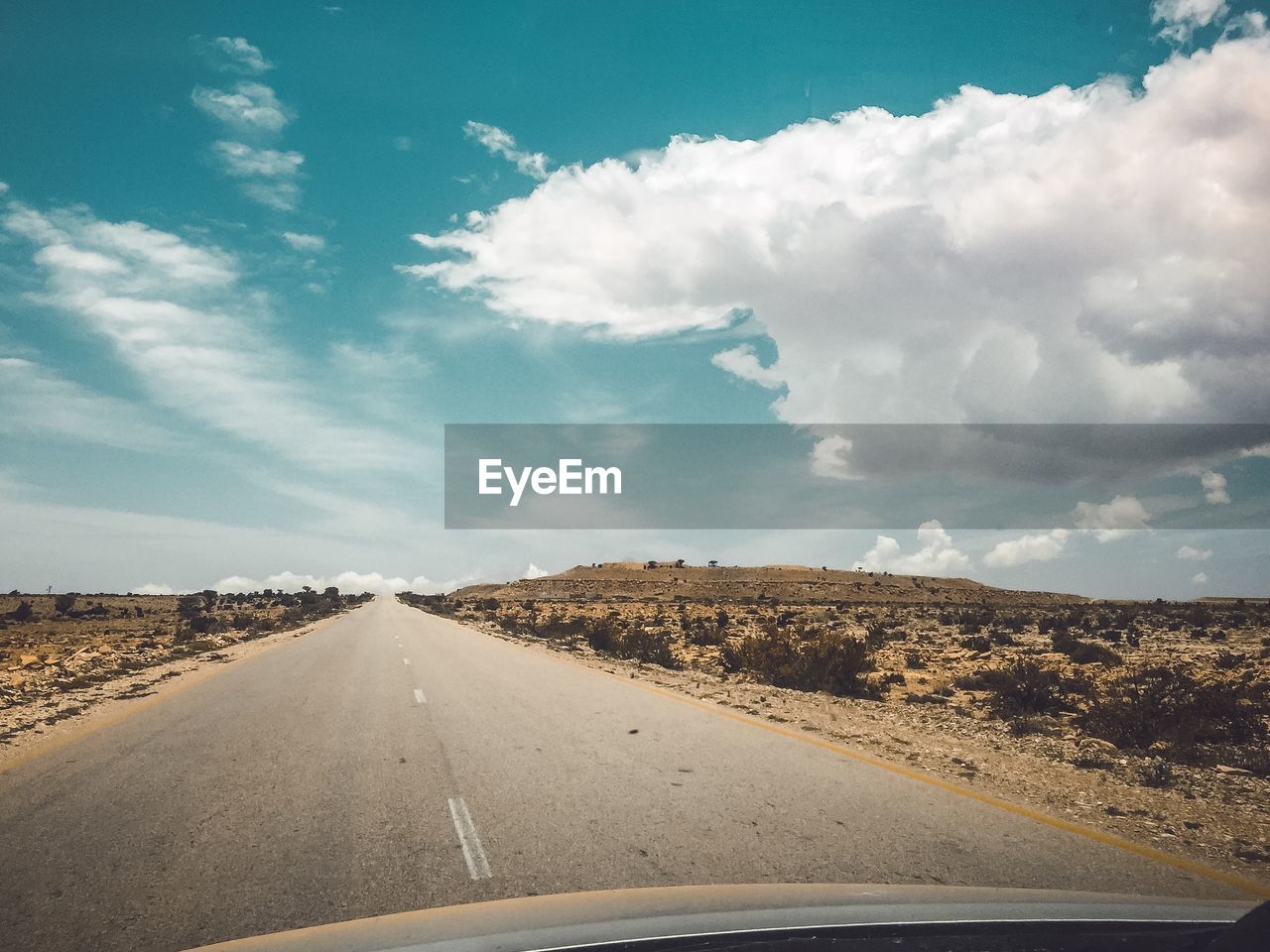 Road against sky seen through car windshield