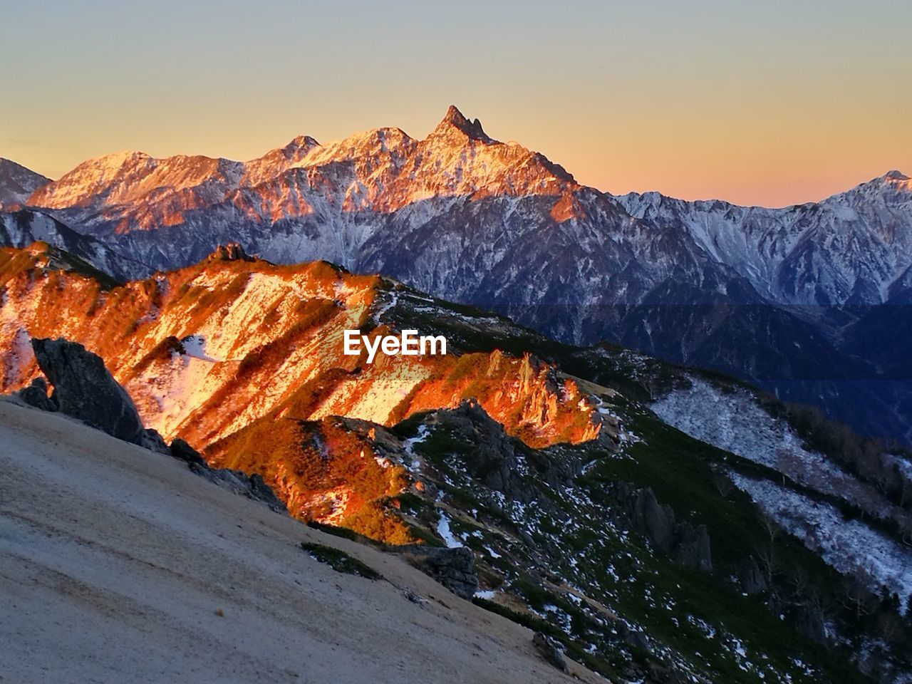 Snow covered mountain against sky during sunset