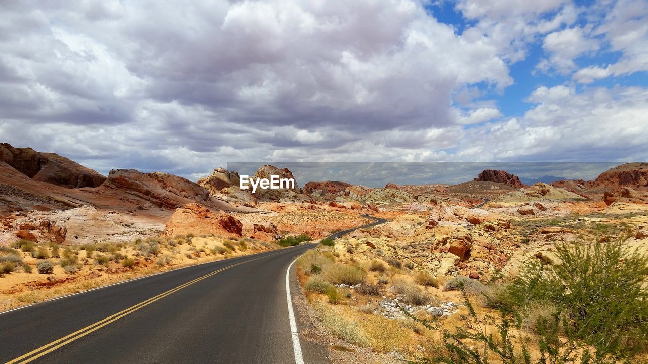 SCENIC VIEW OF ROAD BY MOUNTAINS AGAINST SKY