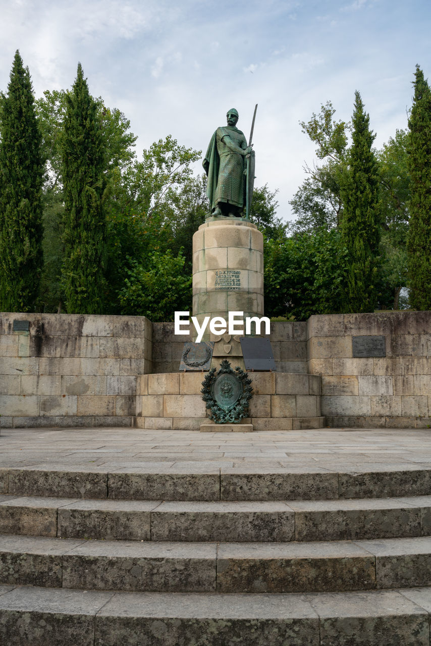 LOW ANGLE VIEW OF STATUE AGAINST TREE