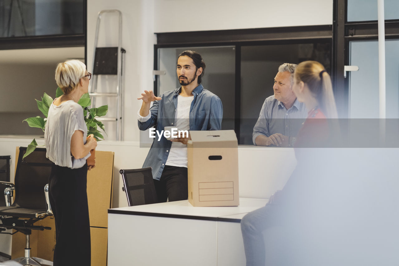 Young businessman discussing with colleagues in new office