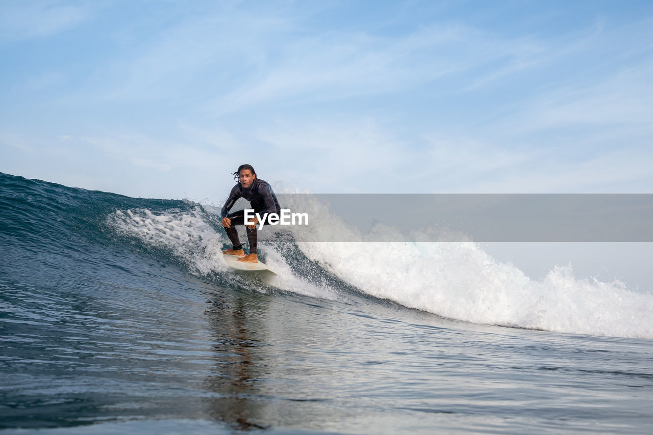 Man surfing on sea against sky