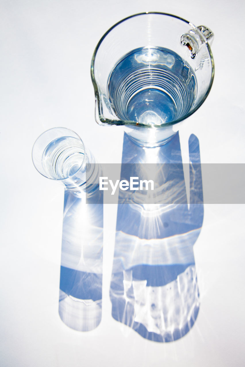 Directly above shot of water jug and glass on gray background