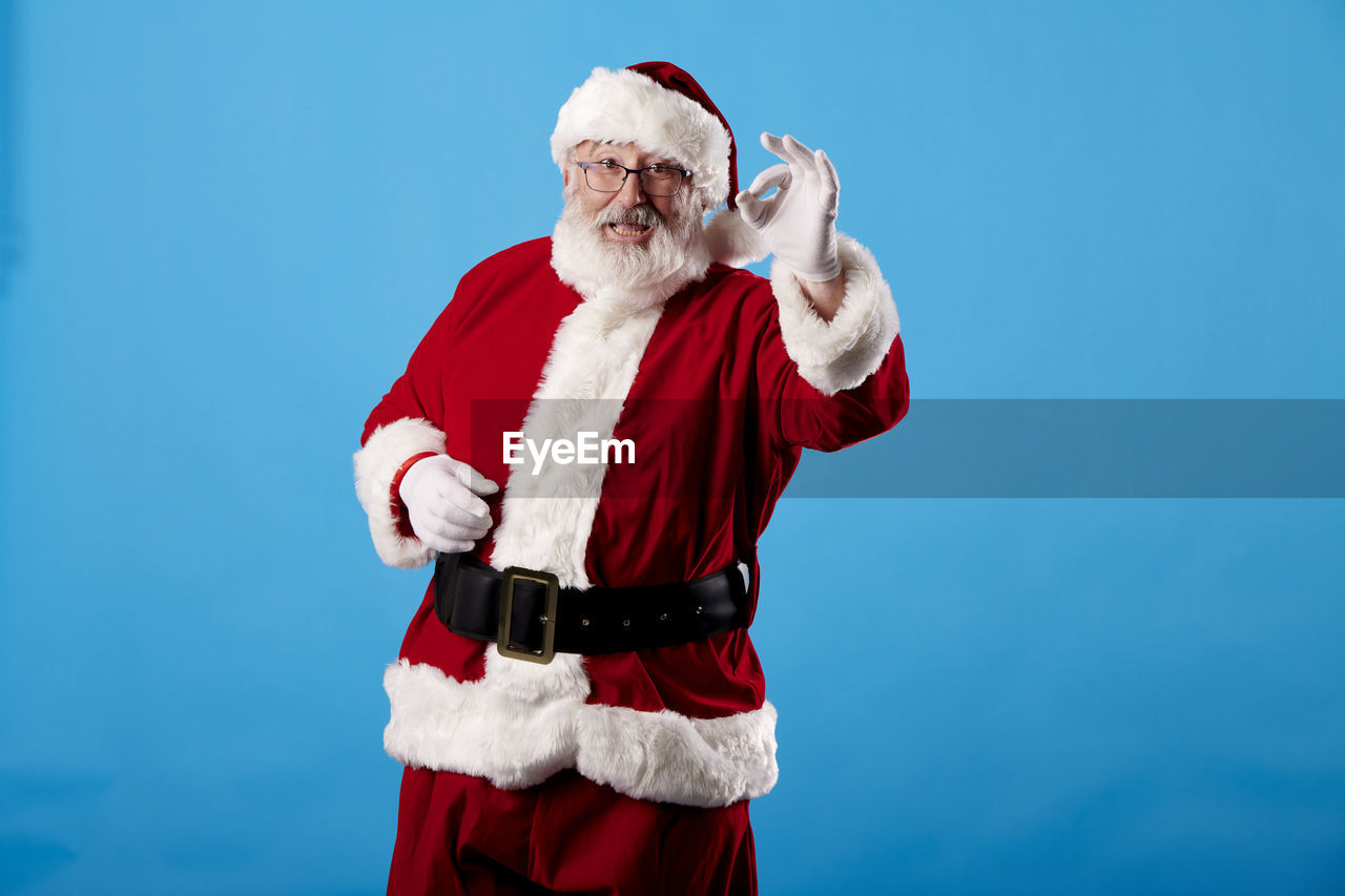 Santa claus making ok gesture on blue background