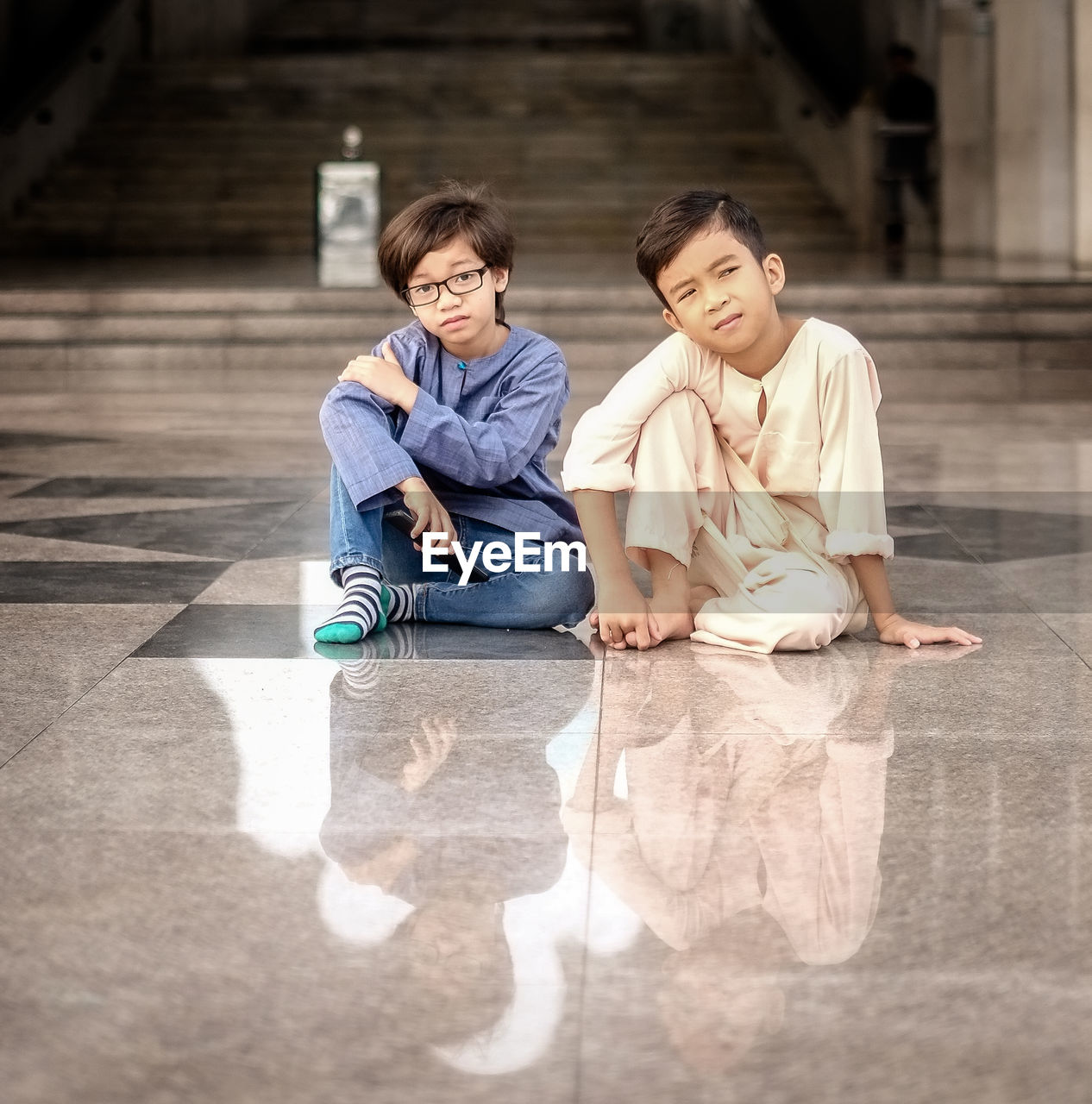 Portrait of cute brothers sitting on floor