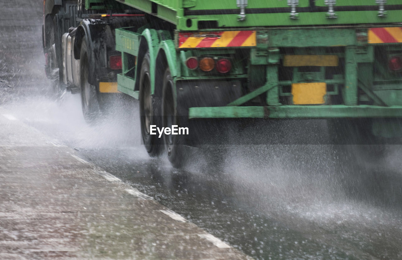 A truck moves along a rainy road