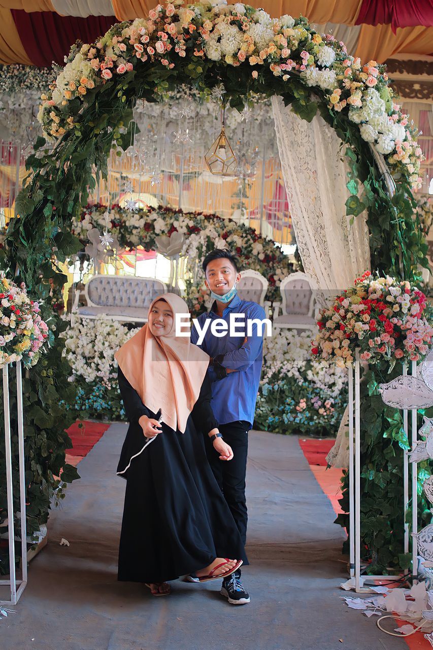 PEOPLE IN FRONT OF WALL AND FLOWER