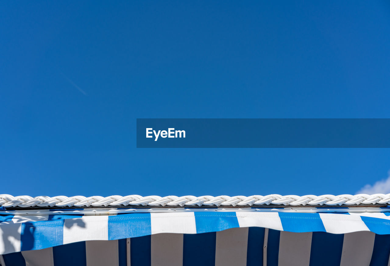 LOW ANGLE VIEW OF RAILING AGAINST BLUE SKY