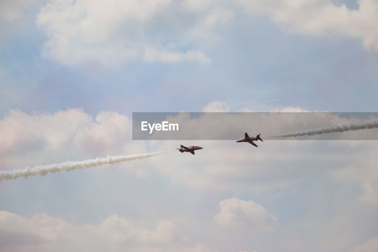 Low angle view of airplanes flying against sky