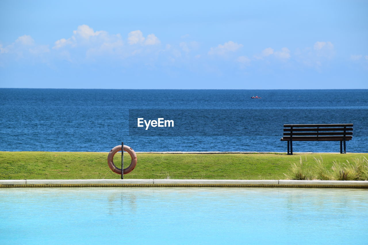 View of swimming pool by sea against sky