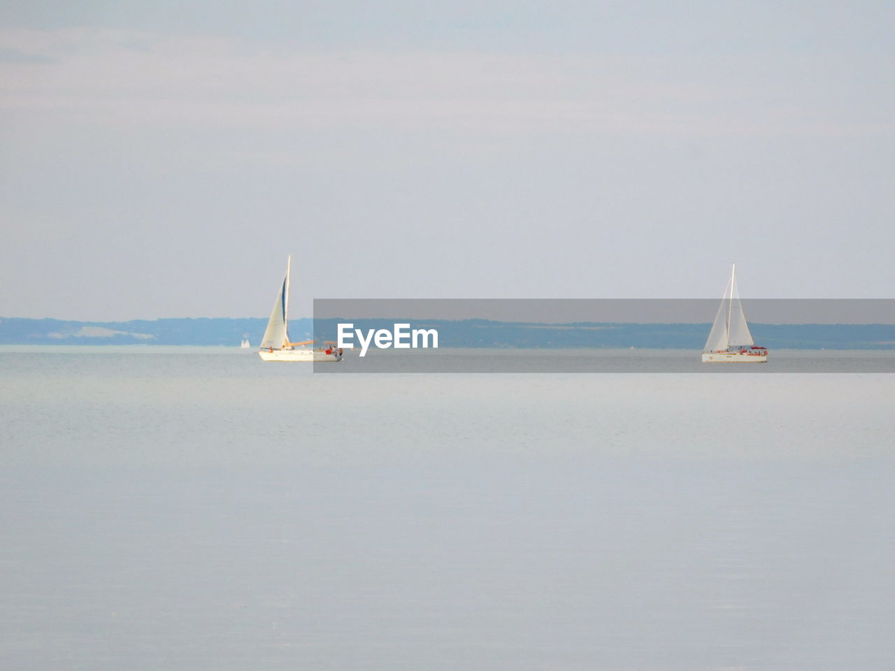 Sailboat sailing on sea against clear sky