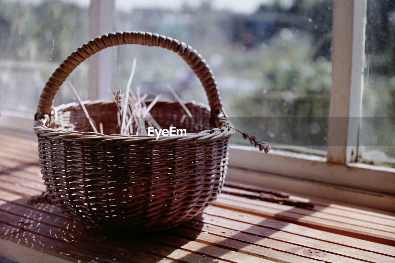 Close-up of wicker basket by window