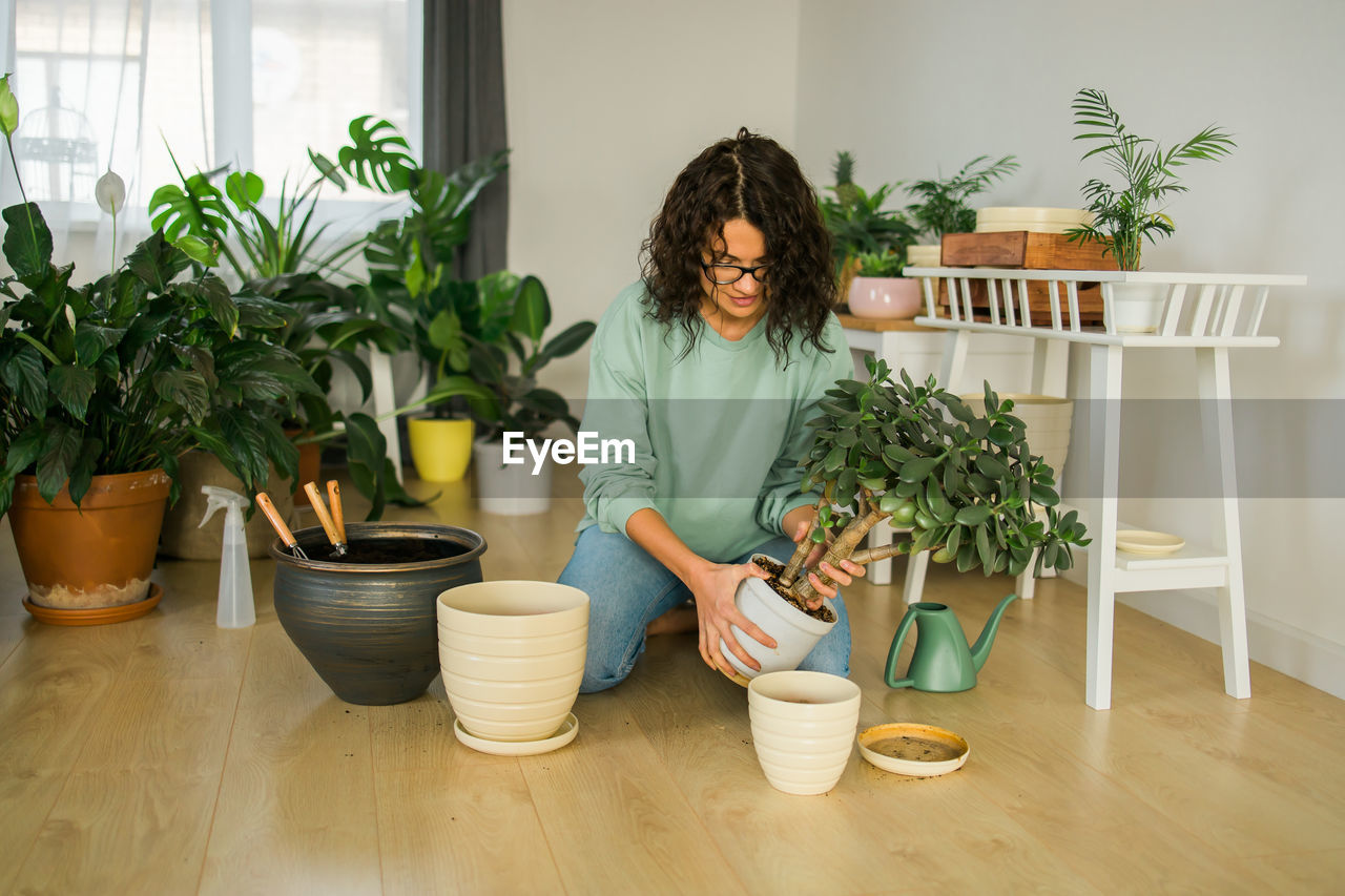 rear view of woman with potted plant on table