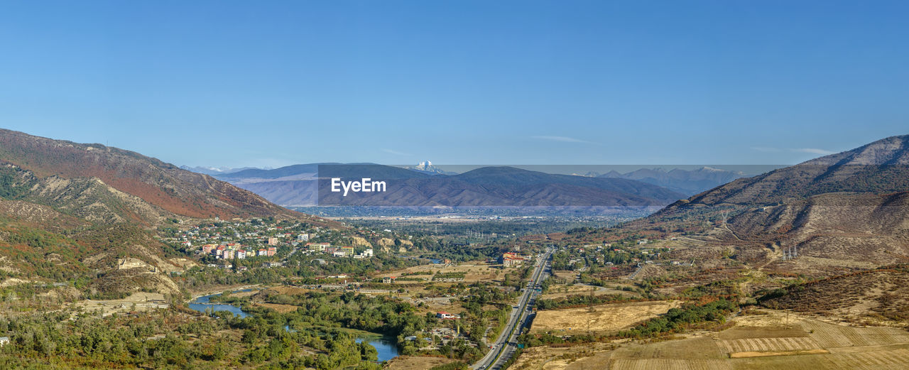 Scenic view of mountains against blue sky