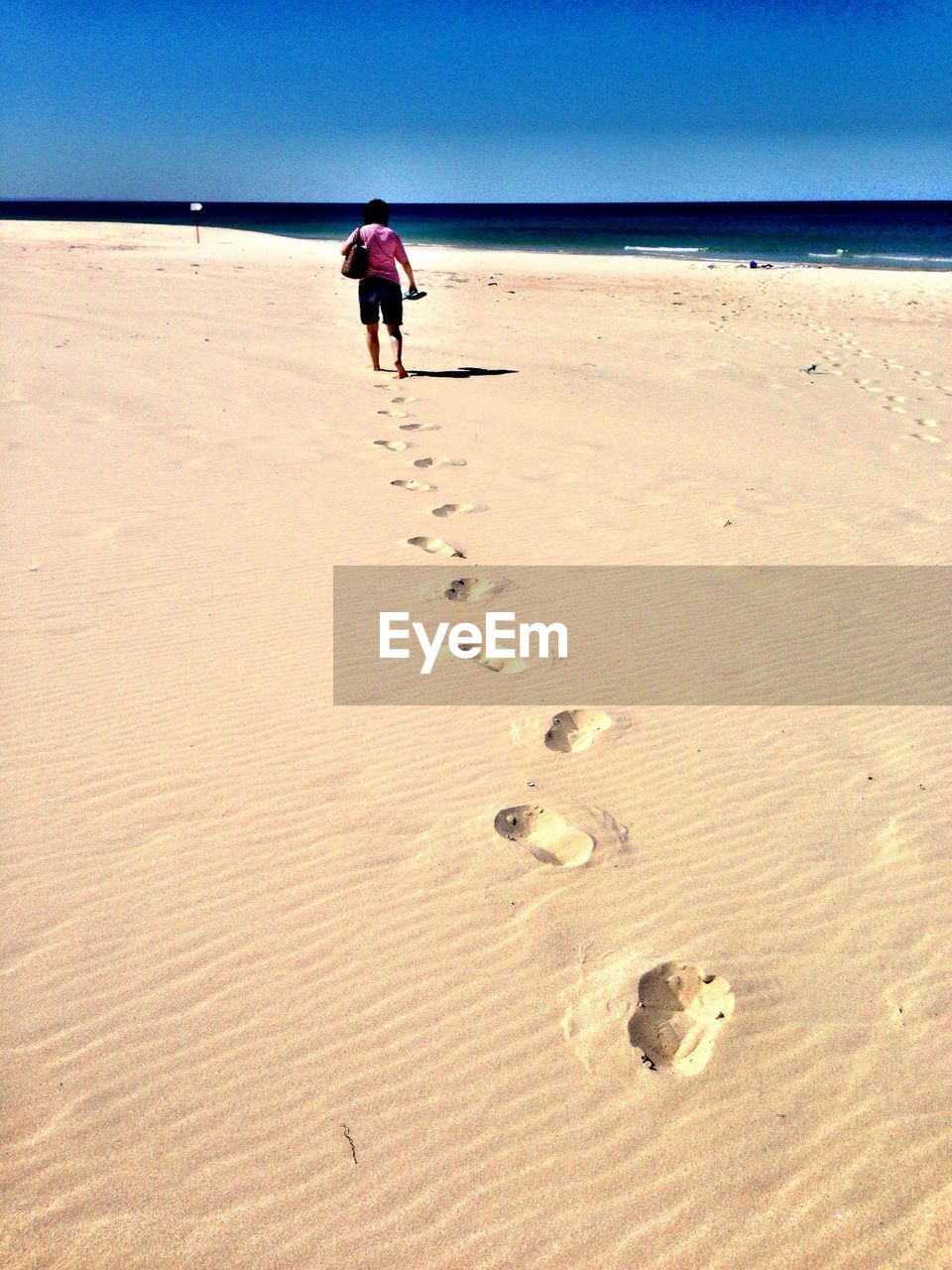 Mid distance of woman with footprints at the beach