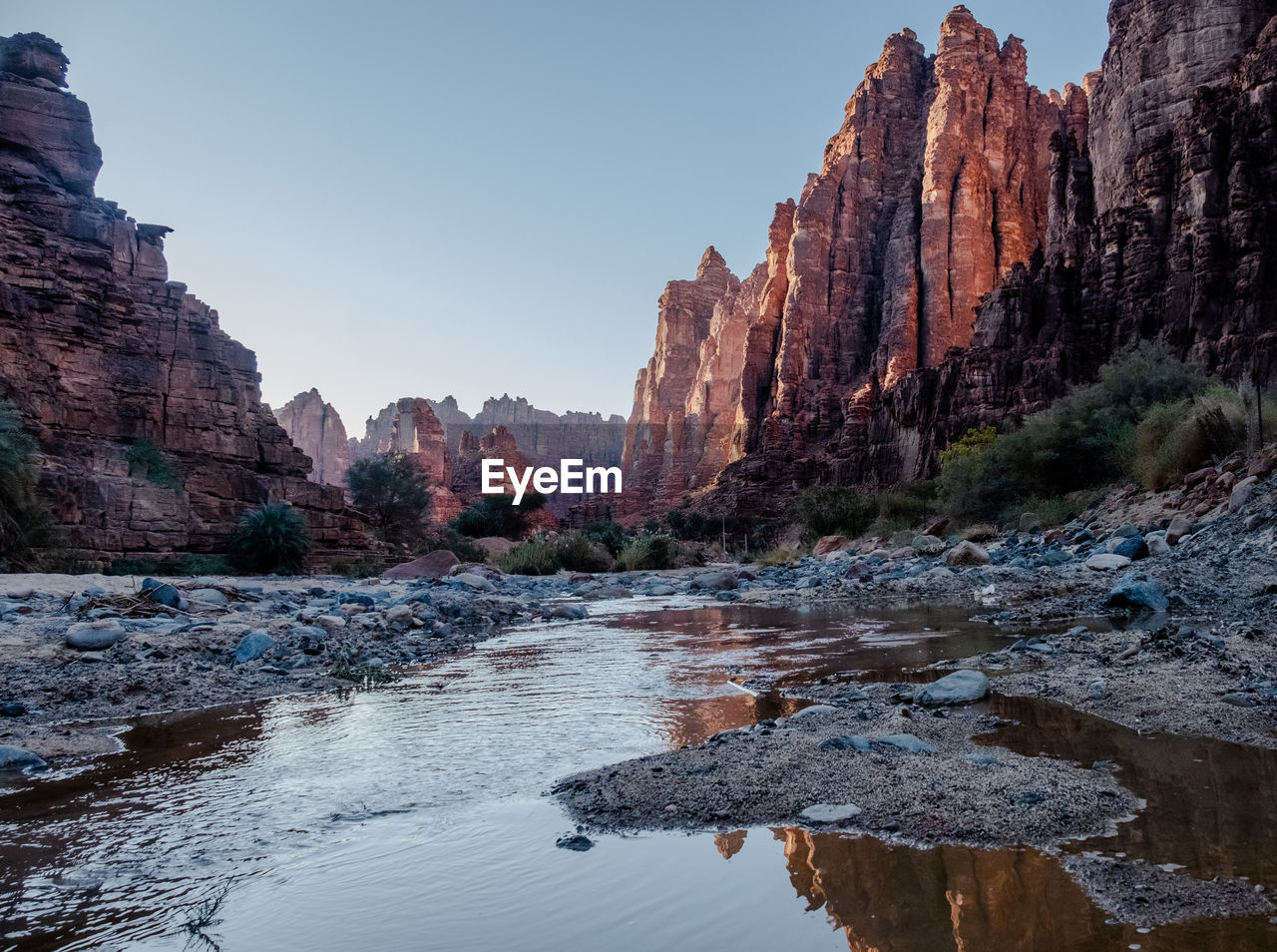 Stream flowing at valley amidst rock mountains