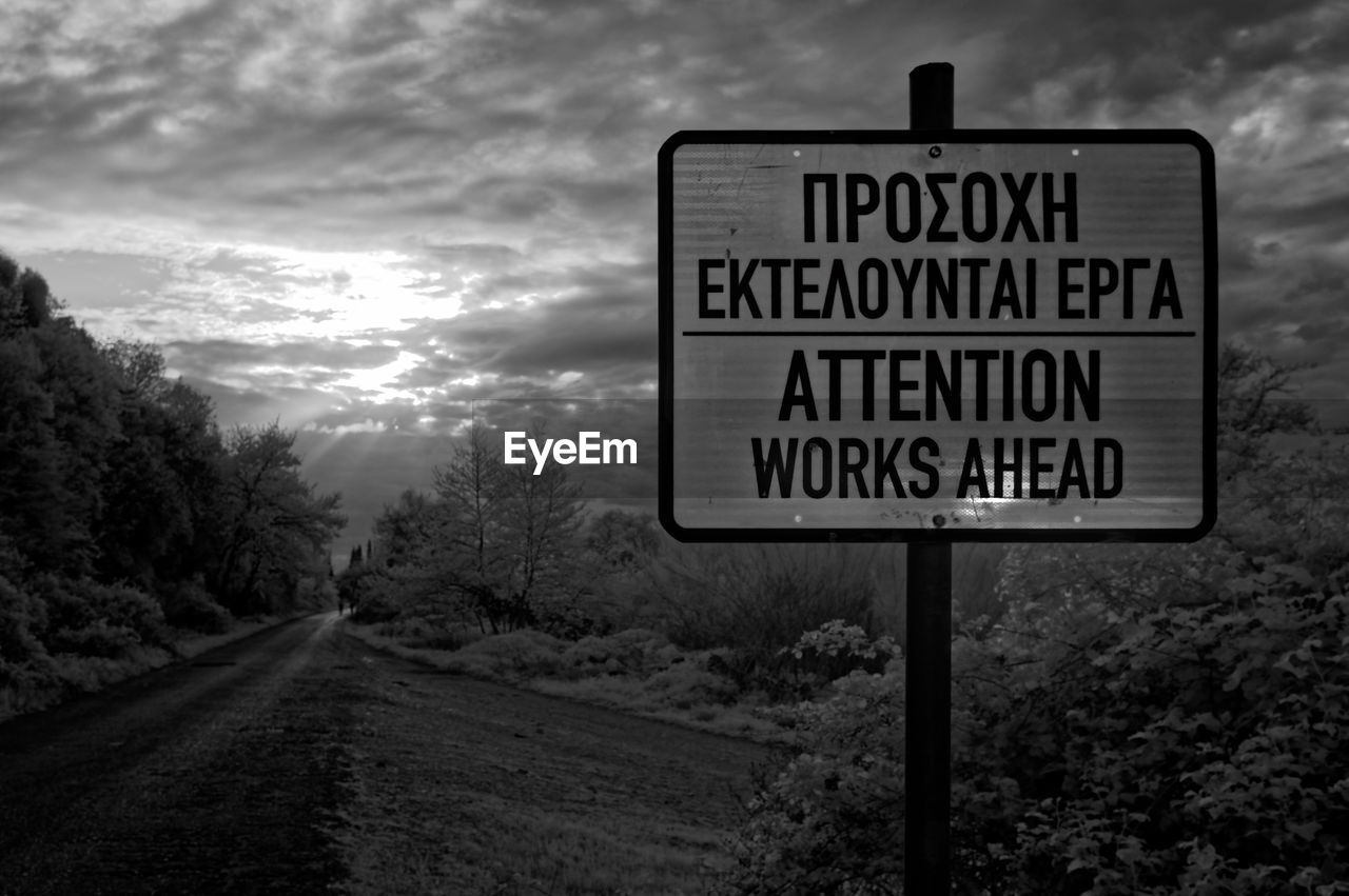 CLOSE-UP OF ROAD SIGN AGAINST TREES
